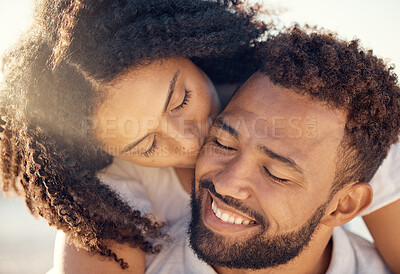 Buy stock photo Piggyback, happy and couple kiss at beach for summer holiday, vacation and romantic date. Love, dating and mixed race man and woman kissing cheek at sunset for bonding, relaxing and honeymoon by sea