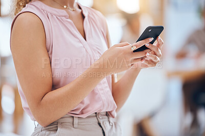 Buy stock photo Closeup cropped view of a unrecognizable mixed race businesswoman stand alone and sending a text using her smartphone in the office at work. Female corporate worker doing online banking with her wireless cell phone



