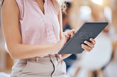 Close up of a business woman\'s hands using a digital tablet in an office. Woman browsing on the internet or interacting with clients on social network