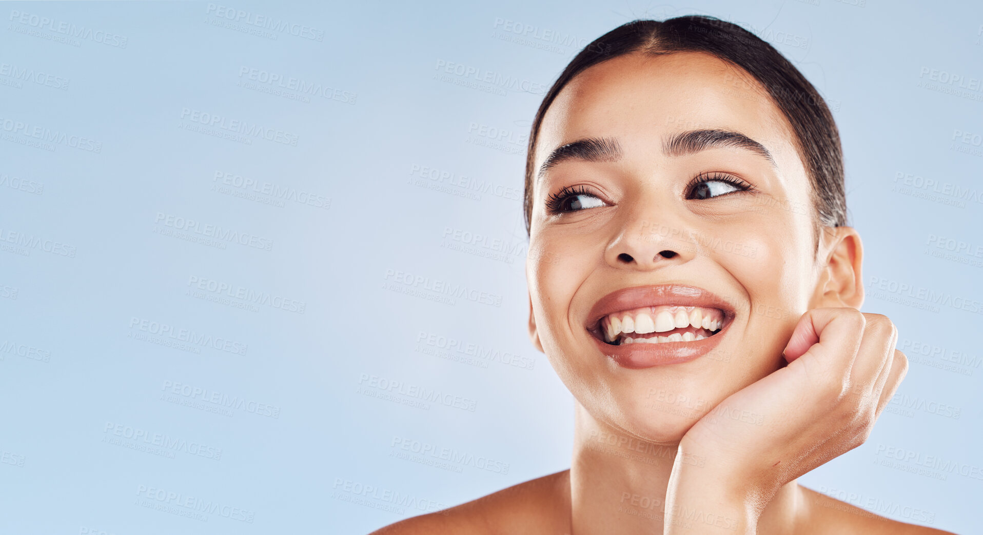 Buy stock photo Closeup face beautiful young mixed race woman. An attractive female posing in studio isolated against a blue background. A skincare regime that keeps your skin soft, smooth, glowing and healthy