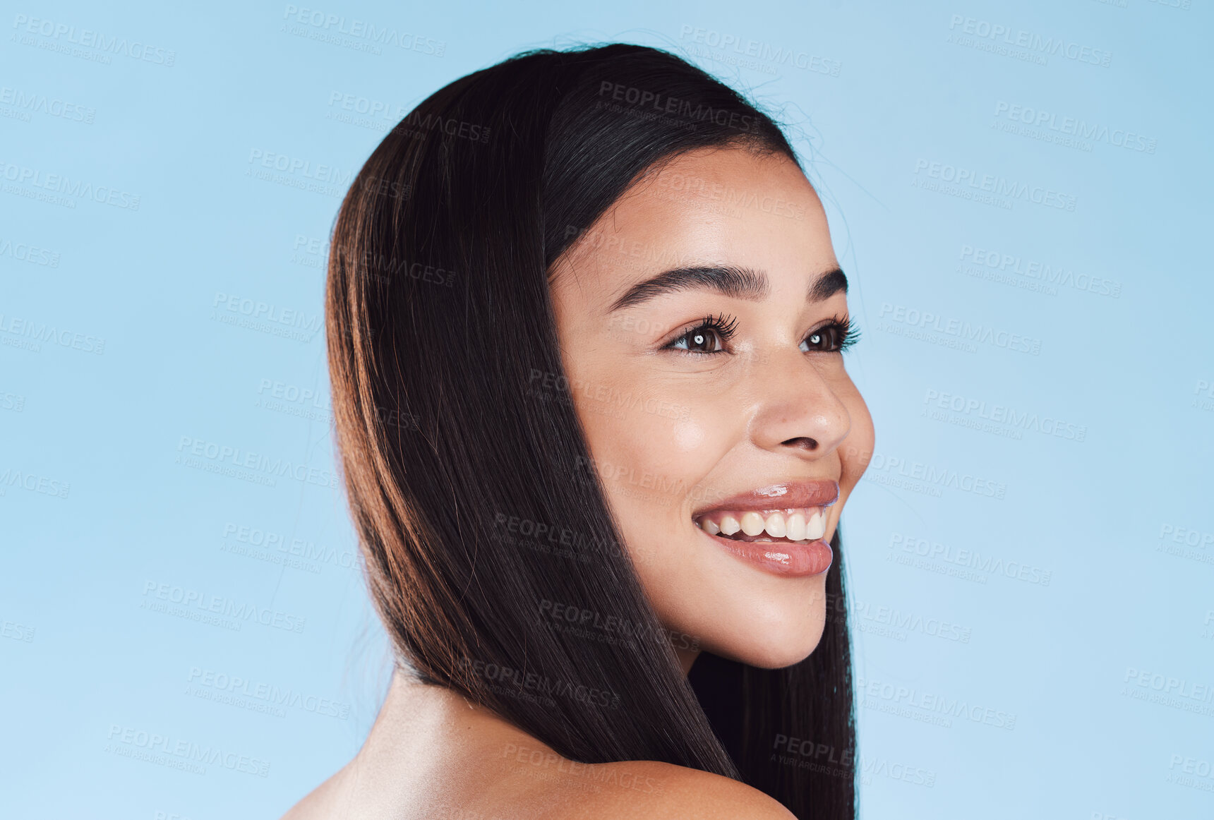 Buy stock photo One beautiful young hispanic woman with healthy skin and sleek hair smiling against a blue studio background. Happy mixed race model with flawless complexion and natural beauty