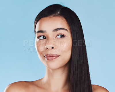 Buy stock photo One beautiful young hispanic woman with healthy skin and sleek hair posing against a blue studio background. Mixed race model with flawless complexion and natural beauty