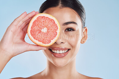 Buy stock photo Portrait of woman with happy face and grapefruit in blue studio background. Her skincare and wellness beauty routine keeps her body fresh or healthy dental hygiene and clean smile or white teeth