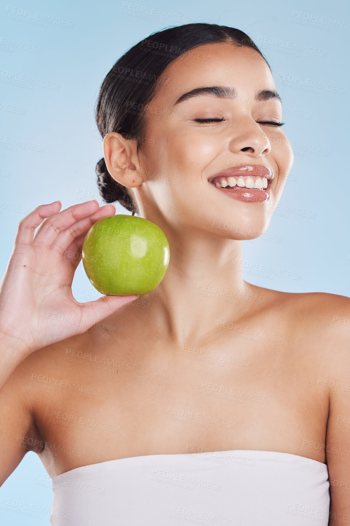 Buy stock photo Skincare, healthcare beauty and woman with apple in hand with sweet fruit, health and dental teeth against a blue studio background. Portrait of a female in healthy natural skin and diet with smile.