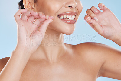 Buy stock photo Healthcare, dental hygiene and a woman flossing her teeth with a smile. Wellness routine, health and floss in hands, happy to take care of your mouth to avoid trip to dentist, with a blue background.