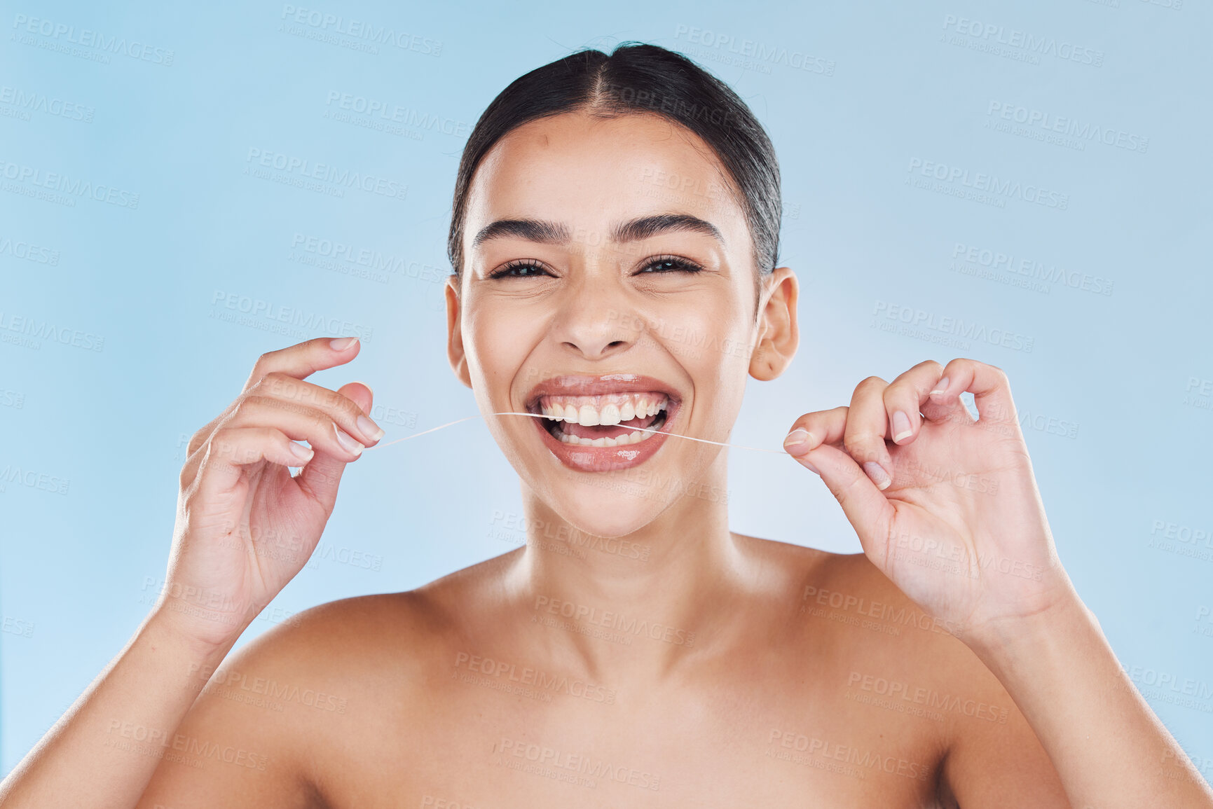 Buy stock photo Beauty, teeth and skincare of a woman in dental floss isolated against a blue studio background. Portrait of attractive female flossing for healthy mouth care, tooth and gum hygiene with a big smile.