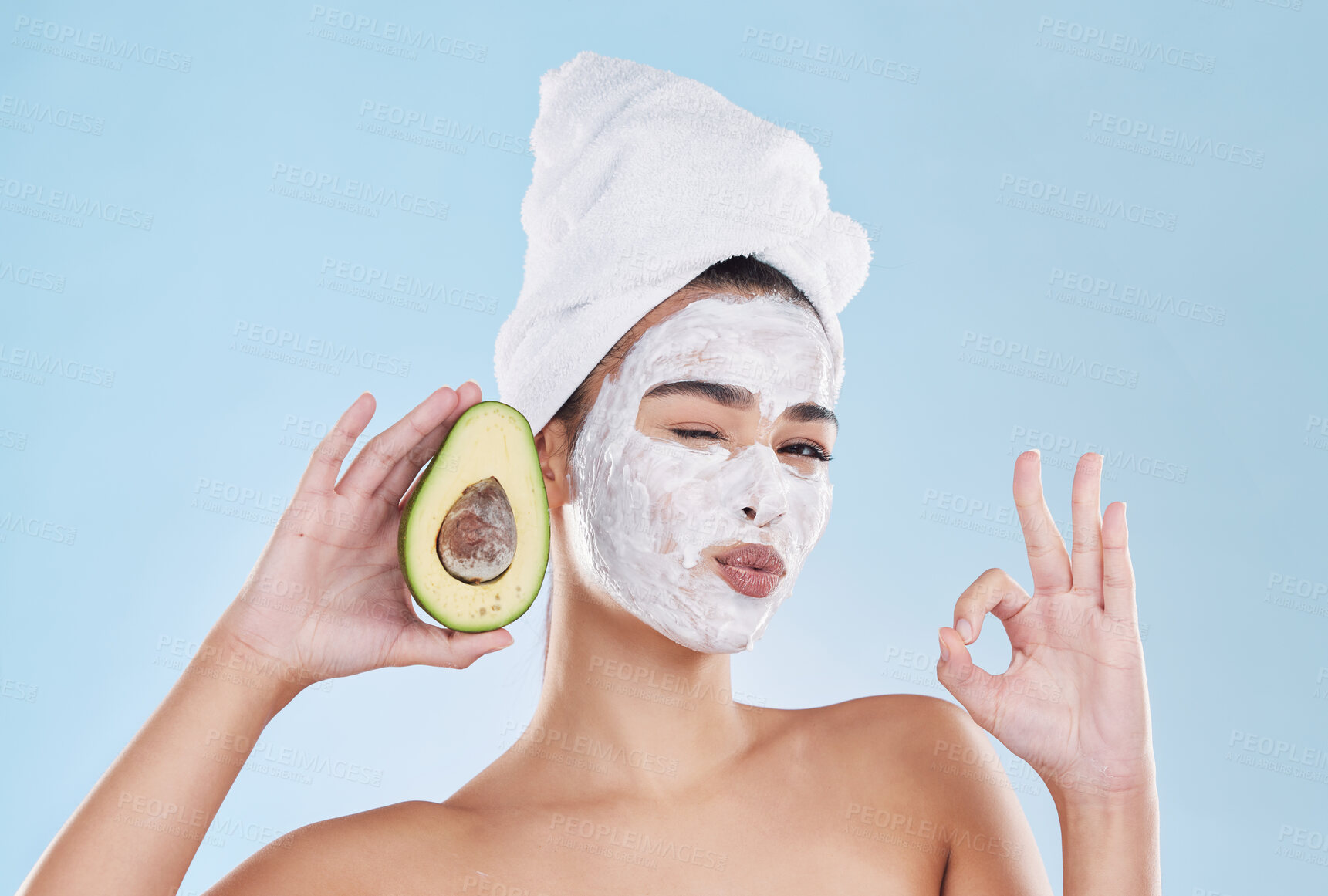 Buy stock photo Face mask, avocado and woman with a ok sign with health, wellness and organic lifestyle in studio. Girl doing fresh, clean and natural selfcare routine while holding fruit for nutrition and diet.