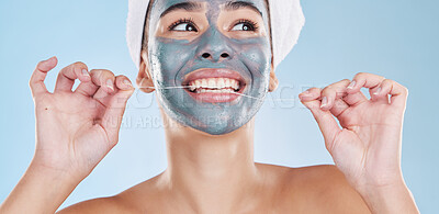 Buy stock photo Dental, face mask and woman flossing teeth in a skincare beauty studio portrait with a blue background. Wellness, smile and happy girl grooming and cleaning her mouth and facial pores to be healthy 