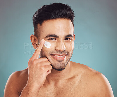 Buy stock photo Portrait, skincare and cream with a man in studio on a gray background to apply antiaging facial treatment. Face, beauty and lotion with a young male person indoor for wellness or aesthetic self care