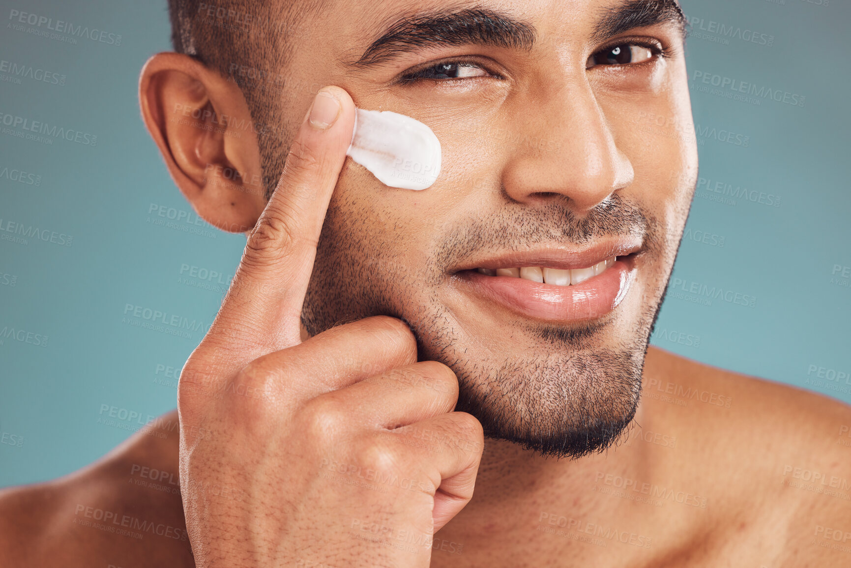 Buy stock photo Portrait, facial and cream with a man in studio on a gray background to apply antiaging skincare treatment. Face, beauty or lotion with a young male person applying spf sunscreen indoor for self care
