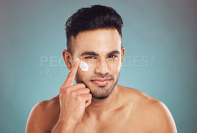 Buy stock photo Portrait, beauty and lotion with a man in studio on a gray background to apply antiaging facial treatment. Face, skincare and cream with a young male person indoor for wellness or aesthetic self care