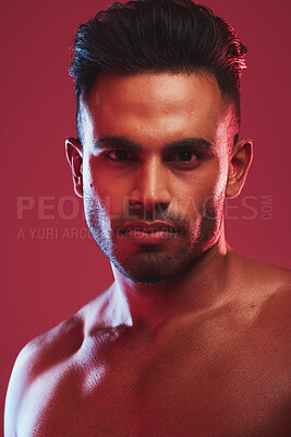 Buy stock photo Closeup portrait of one fit and strong handsome mixed race man isolated against a red background in a studio and posing shirtless. Headshot of  serious and focused hispanic man looking determined