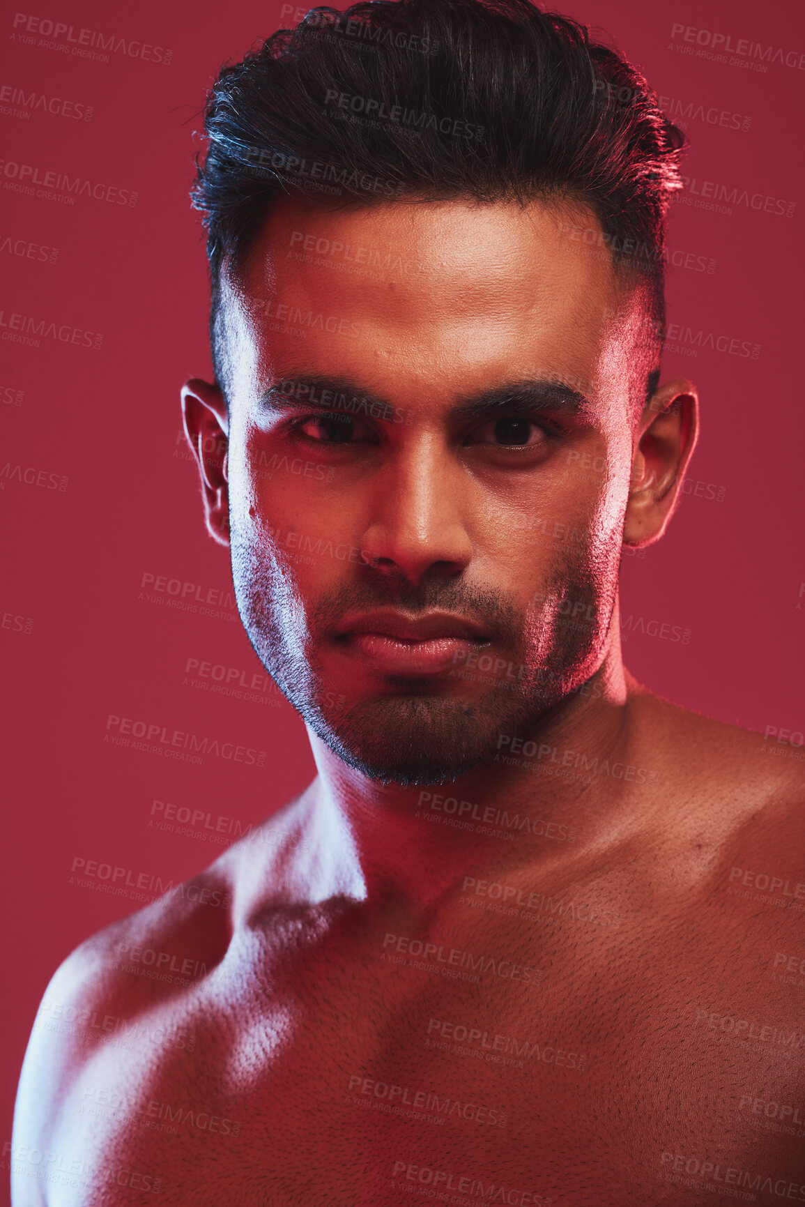 Buy stock photo Closeup portrait of one fit and strong handsome mixed race man isolated against a red background in a studio and posing shirtless. Headshot of  serious and focused hispanic man looking determined