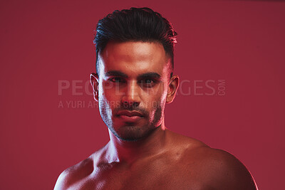 Buy stock photo Closeup portrait of bare chested athletic young man posing against a red background. Handsome young masculine hispanic man looking confident while posing in the studio 
