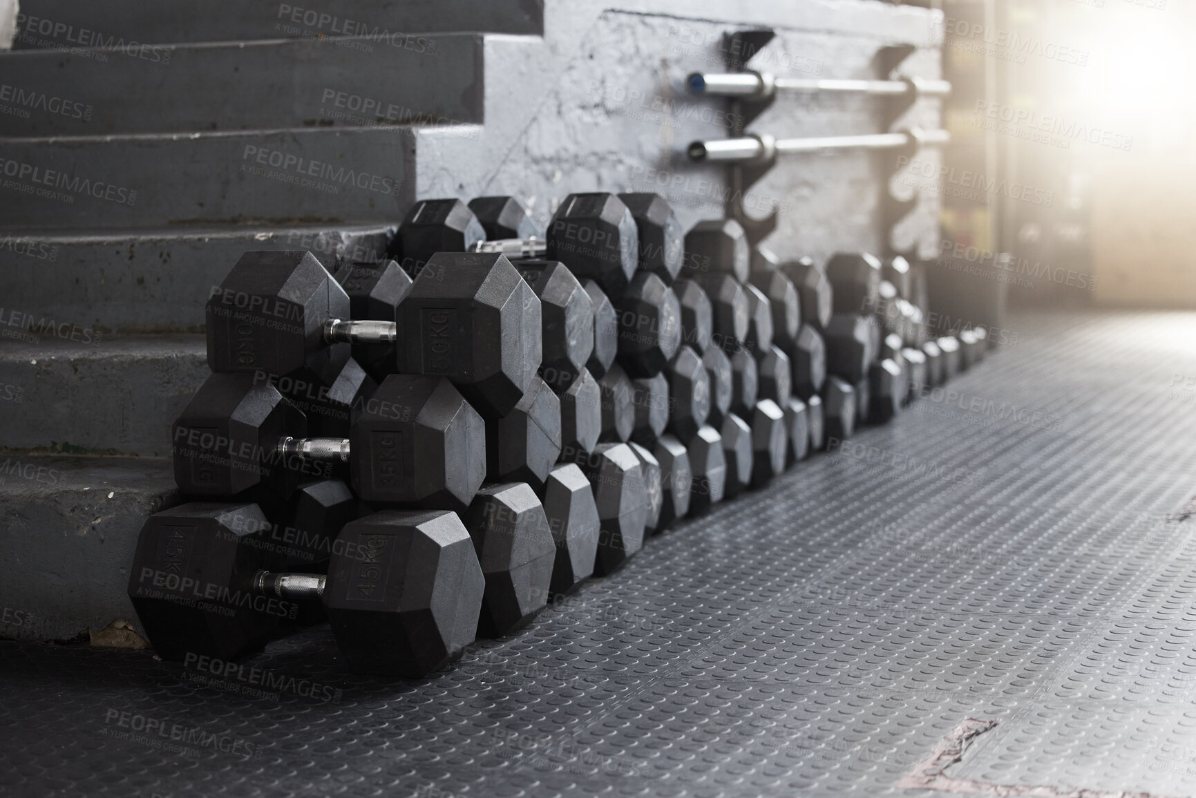 Buy stock photo Equipment, gym weights and floor of room or empty facility for fitness, sports and exercise club mockup. Dumbbells, barbell stack and weight rack in a dark training gymnasium for workout class