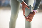Active woman holding her leg in pain while exercising outdoors. Closeup of an athlete suffering with a painful knee injury, causing discomfort and strain. Bone and muscle sprain from a fractured joint