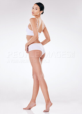 Portrait of a beautiful young mixed race model posing seductively in underwear against a grey studio copyspace background. Confident hispanic woman showing her curvy shape and smooth hairless skin