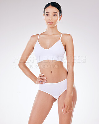 Portrait of a beautiful young mixed race model posing seductively in underwear against a grey studio copyspace background. Confident hispanic woman showing her curvy shape and smooth hairless skin