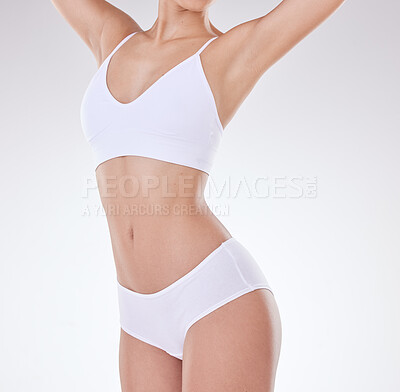 Closeup of unrecognizable mixed race model\'s hairless body and slim waist posing against a white copyspace background. Unknown Hispanic woman feeling fresh while showing her healthy belly and skin