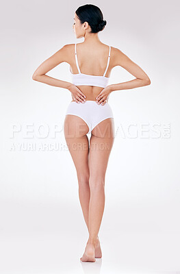 Buy stock photo Rear view of one mixed race model posing in underwear against a white background studio. Hispanic female removing her bra while showing her thick shape in a studio