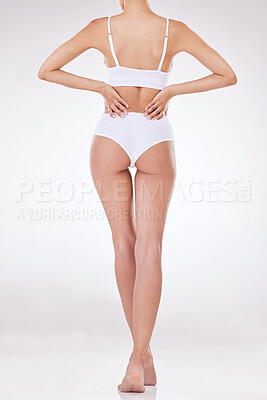 Rear view of one unrecognizable model posing in underwear against a white background studio. Unknown hispanic female showing her thick shape in a studio
