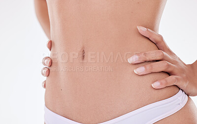 Closeup of unrecognizable mixed race model\'s hairless body and slim waist posing against a white copyspace background. Unknown Hispanic woman feeling fresh while showing her healthy belly and skin