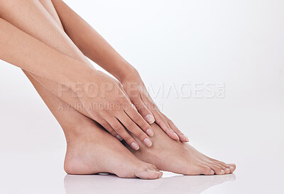 Closeup of unrecognizable woman posing against a white studio background. One female only feeling confident while showing her hairless, smooth legs after hair removal or epilation