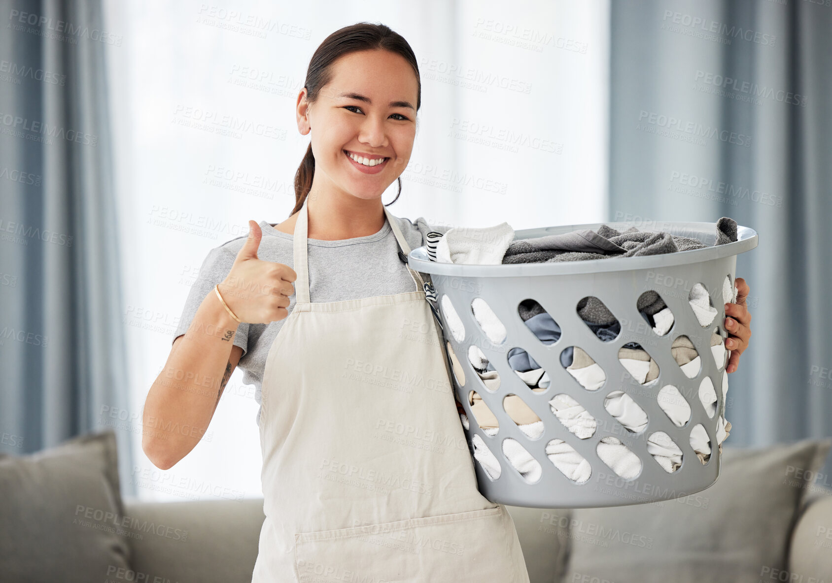Buy stock photo Happy asian woman, laundry and thumbs up for housekeeping, cleaning or hygiene at home. Portrait of female person, cleaner or domestic with smile and thumb emoji, yes sign or like for clean clothing