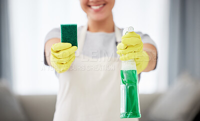One unrecognizable woman holding a cleaning product and sponge while cleaning her apartment. An unknown domestic cleaner wearing latex cleaning gloves