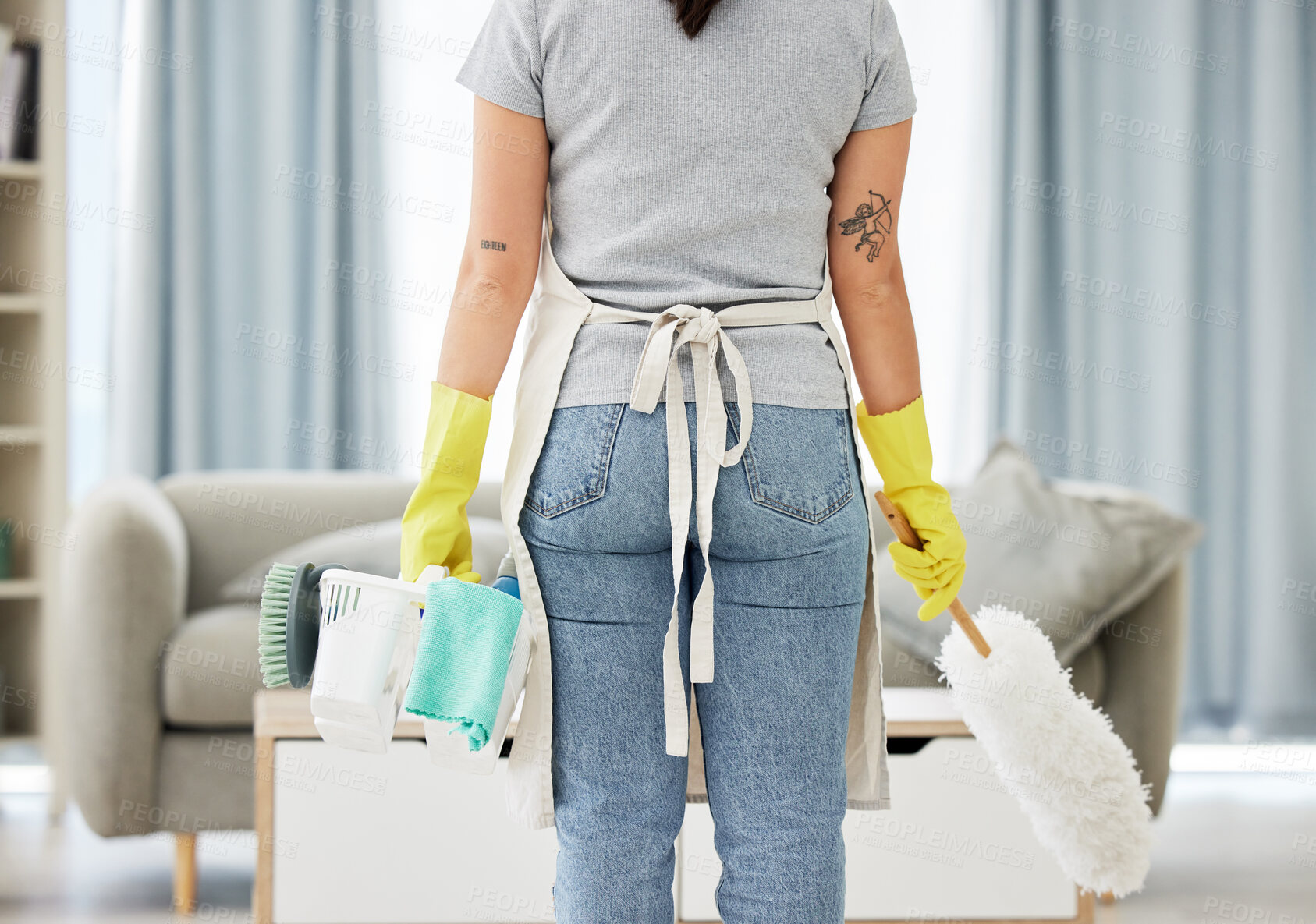 Buy stock photo Woman, housekeeper and back with supplies for cleaning, hygiene or disinfection in living room at home. Rear view of female person, cleaner or maid with clean equipment or tools for dirt or dust