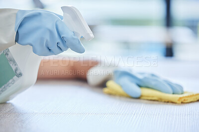 One unknown young mixed race woman cleaning the surfaces of her home. Unrecognizable Hispanic domestic worker wiping a table
