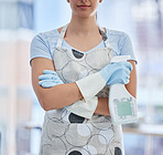 One unrecognizable woman holding a cleaning product while cleaning her apartment. An unknown domestic cleaner wearing latex cleaning gloves
