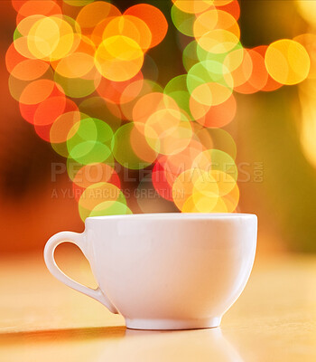 Closeup of a cup isolated against a vibrant bokeh background. One white teacup on a table. Crockery used to enjoy a warm beverage from such as tea or coffee in a cafe or at home
