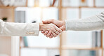 Two businesspeople shaking hands in a meeting at work. Business professionals greeting and making deals with each other. Boss hiring an employee in an interview in an office