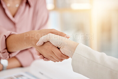 Two caucasian businesswomen shaking hands in a meeting at work. Business professionals greeting and making deals with each other. Boss giving an employee a promotion