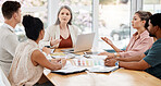 Group of five diverse businesspeople having a meeting in an office at work. Focused businesspeople talking during a workshop. Businesspeople sitting and planning together