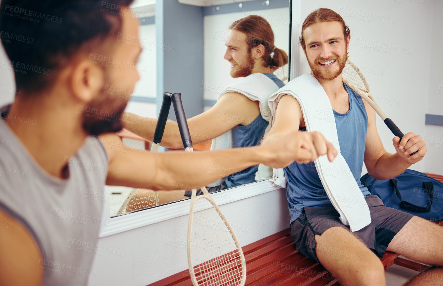 Buy stock photo Two squash players giving each other a fist bump. Cheerful friends bonding in a gym locker room. Athletes being social and bonding with each other. Players fist bumping one another before a match