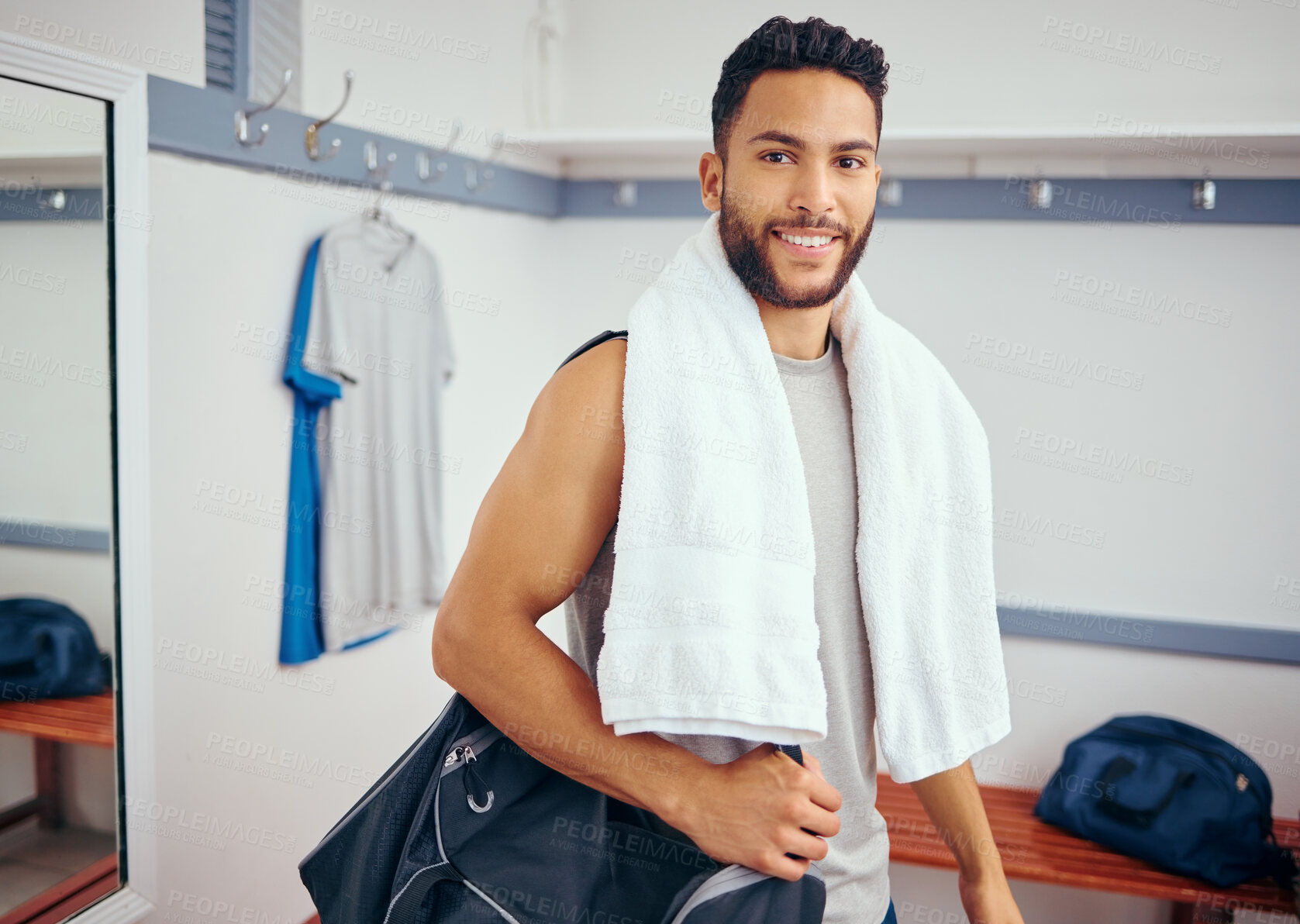 Buy stock photo Portrait of a happy player in his gym locker room. Mixed race man ready for a squash match. Young man relaxing in his gym after a game. Young man carrying his gym bag through his locker room