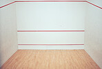 Empty squash court in a sports centre. Three walled court with nobody and copyspace in a training and practice club. Red line markings on a wall with a wooden timber floor in a sporty arena and room
