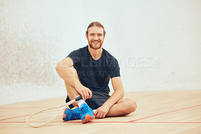 Buy stock photo Portrait of young athletic squash player taking break after playing court game with copyspace. Full length of one smiling caucasian athlete sitting after training practice in sports centre. Fit active