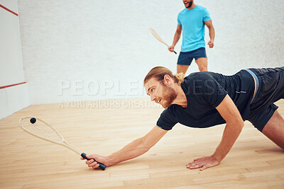 Buy stock photo Two athletic squash players playing match during competitive court game. Fit active mixed race and caucasian athlete competing during training challenge in sports centre. Sporty men in championship