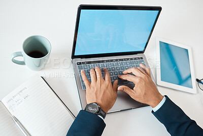 Buy stock photo Closeup of a mixed race businessman typing an email on a laptop alone at work from above. One hispanic male businessperson working on a laptop in an office at work