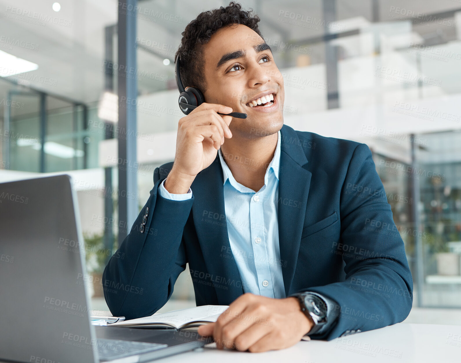 Buy stock photo Young happy mixed race male call center agent answering calls while wearing a headset and thinking alone at work. One hispanic male assistant smiling while talking on a call at a desk in an office