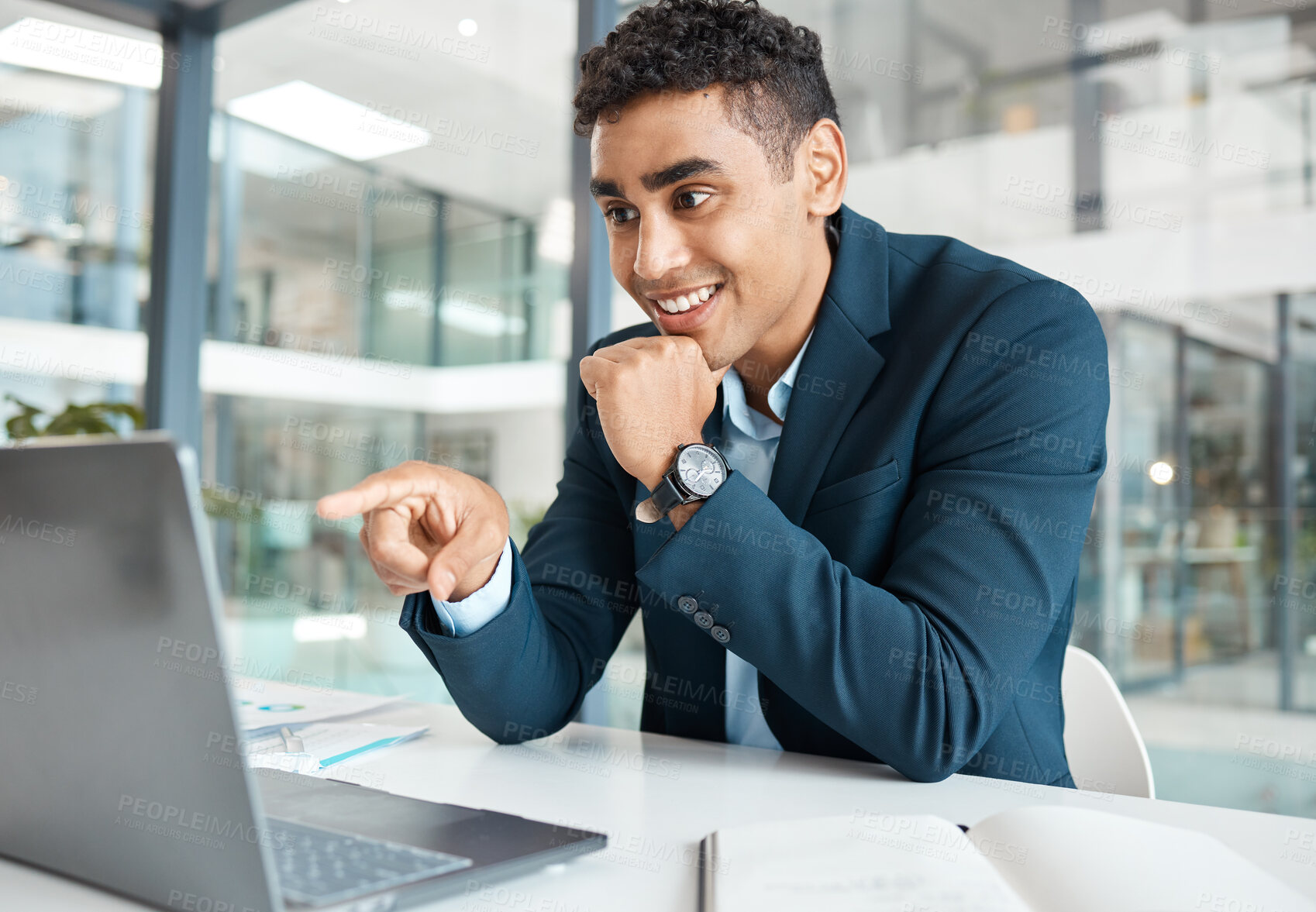 Buy stock photo Young happy mixed race businessman pointing a finger while working on a laptop alone at work. Hispanic male businessperson smiling and reading an email on a laptop while pointing a finger working in an office