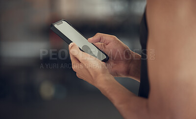 Buy stock photo Hands of a man sending a text on his smartphone in the gym. Man taking a break from exercise to use his cellphone. Screen of a mobile phone being used in the gym.Man using a cellphone cropped