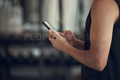 Buy stock photo Hands of a man using his cellphone at the gym. Closeup on hands of a man using his smartphone in the gym. Bodybuilder taking a break from exercise to use his mobile phone. Man using an app in the gym
