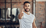 Portrait of young athlete giving thumbs up. Young fit man doing his best to endorse exercise in the gym. Young athlete making a gesture in the gym. Muscular young man making a hand gesture in the gym