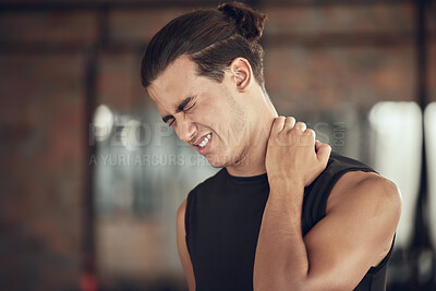 Buy stock photo Bodybuilder experiencing a neck cramp in the gym. Fit young man with neck pain in the gym. Athletic muscular man with neck ache in the gym. Strong man with a sore injured neck in the gym