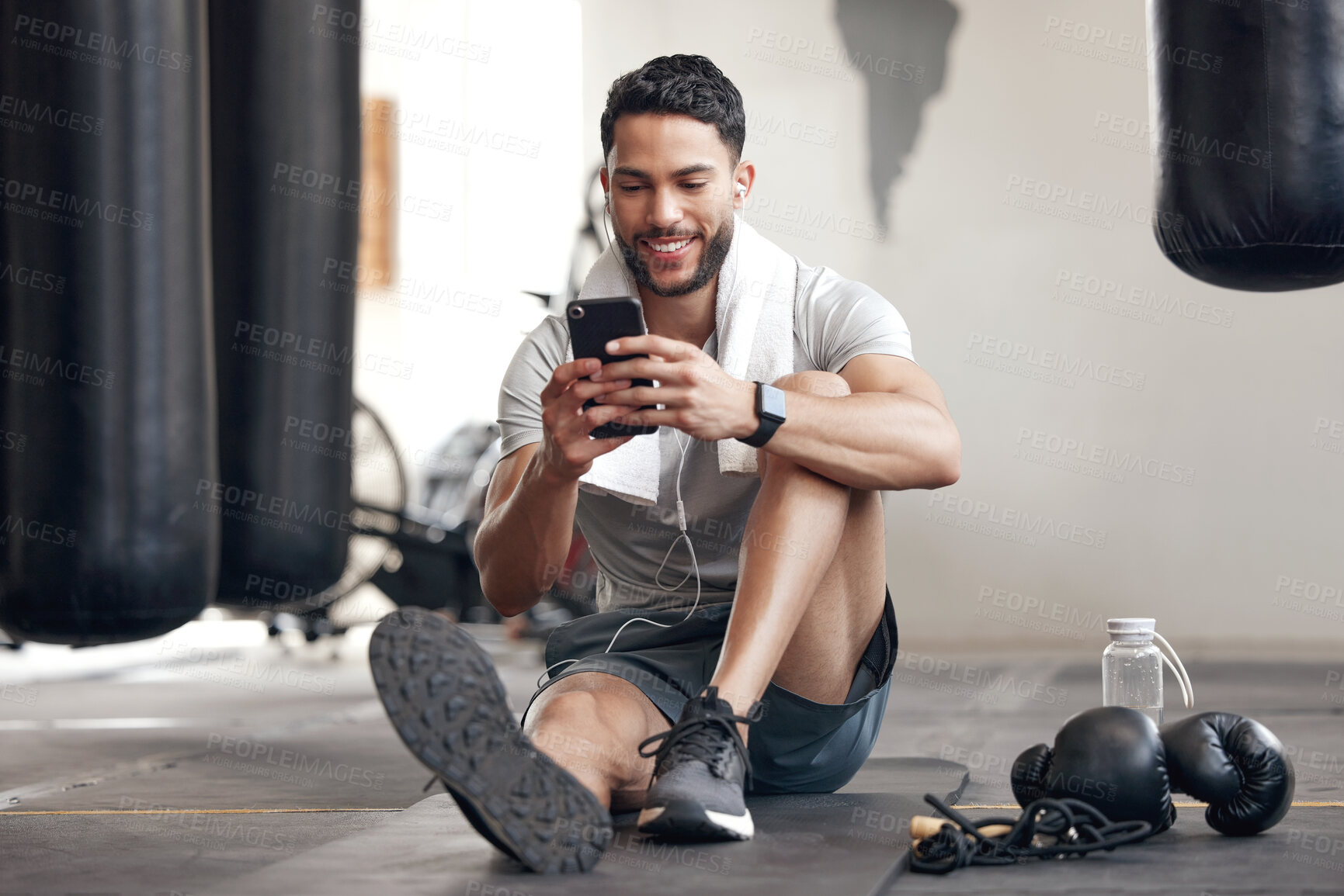 Buy stock photo Fitness, man with smartphone and earphones at the gym happy for training or health wellness. Meditation or commitment, exercise or workout and male athlete listen to music or podcast for motivation