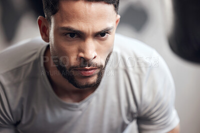 Buy stock photo Closeup of one serious young hispanic man focused on his exercise session in a gym. Face of a determined mixed race guy getting mentally prepared to stay motivated and dedicated during a training workout in a fitness centre